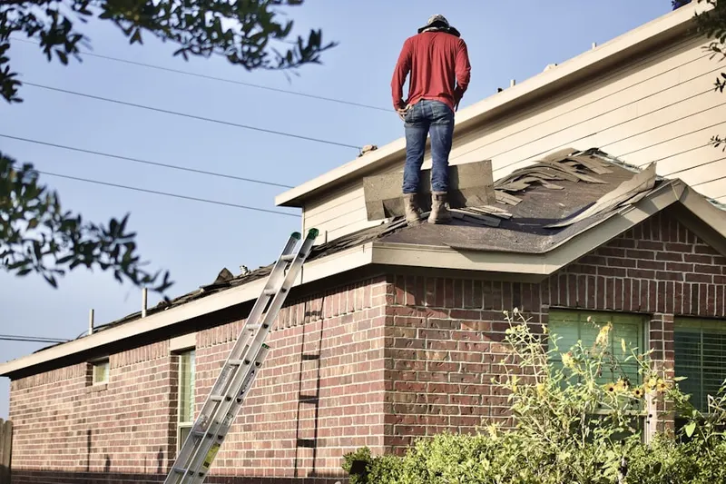 Professional roofer working on a residential roof in Biscoe